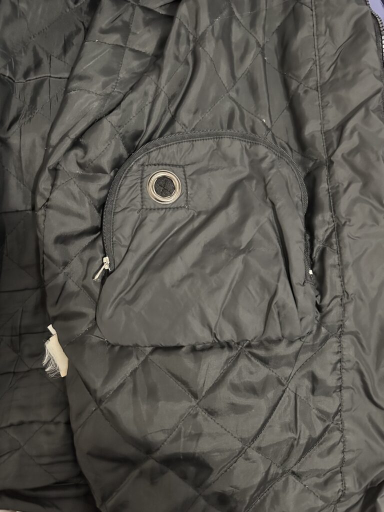 The inside of a jacket showing a Discman-sized pocket with a zipper and a hole for the headphone cable.